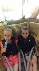 London and Nathaniel "doing their vest." Each of them wears an inCourage vest for about 30 minutes each day to keep their lungs free of mucous. London also takes medication through a nebulizer.